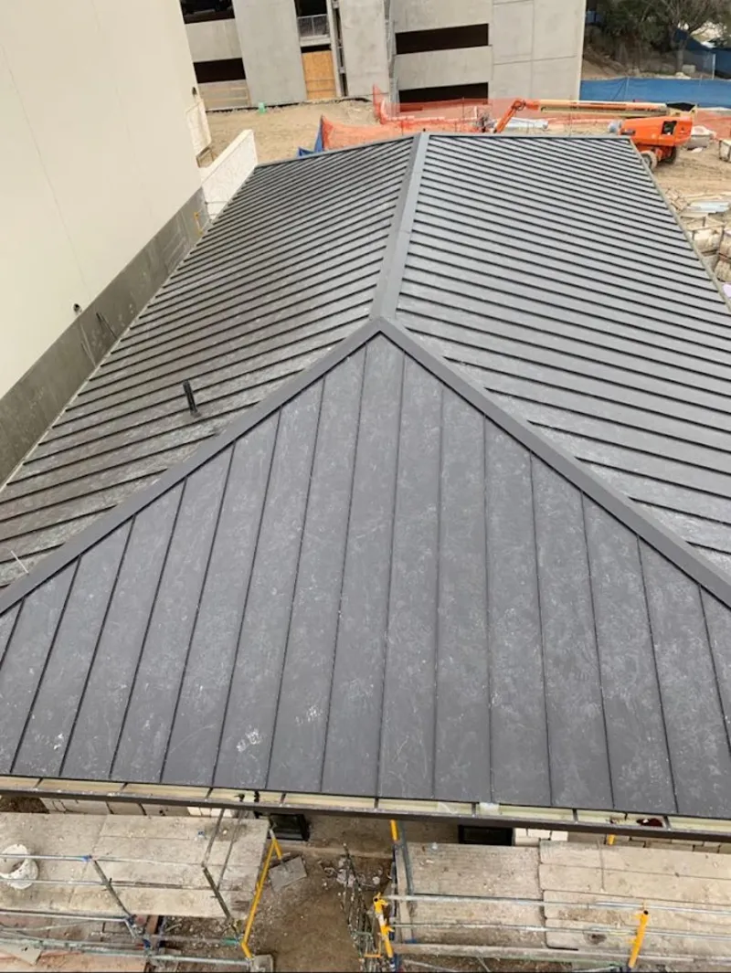 Commercial metal roof construction with crane equipment in Mansfield